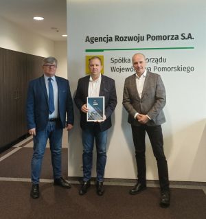 dwaj wiceprezesi Agencji Rozwoju Pomorza z przedstawicielem firmy Bionea na tle ściany